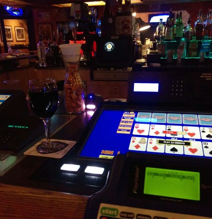 Video poker at the bar top with a glass of wine
